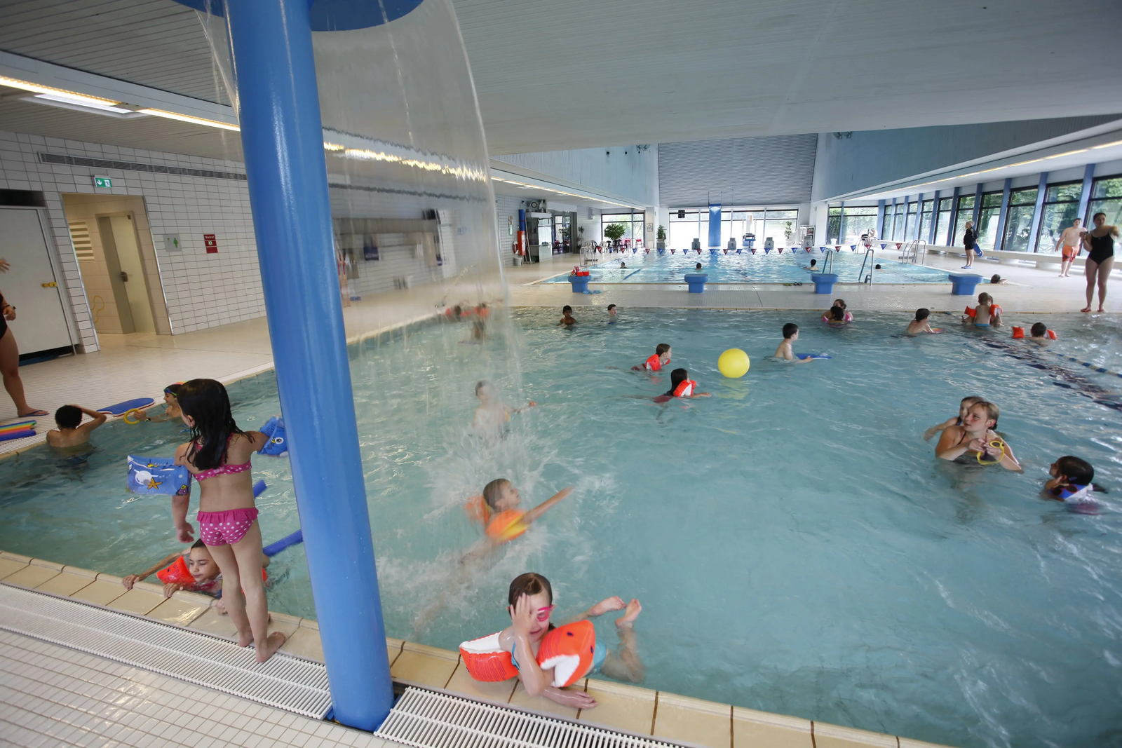 Kleinkinder planschen im belibten Kinderbecken mit Schwalldusche im Hallenbad Zuffenhausen.