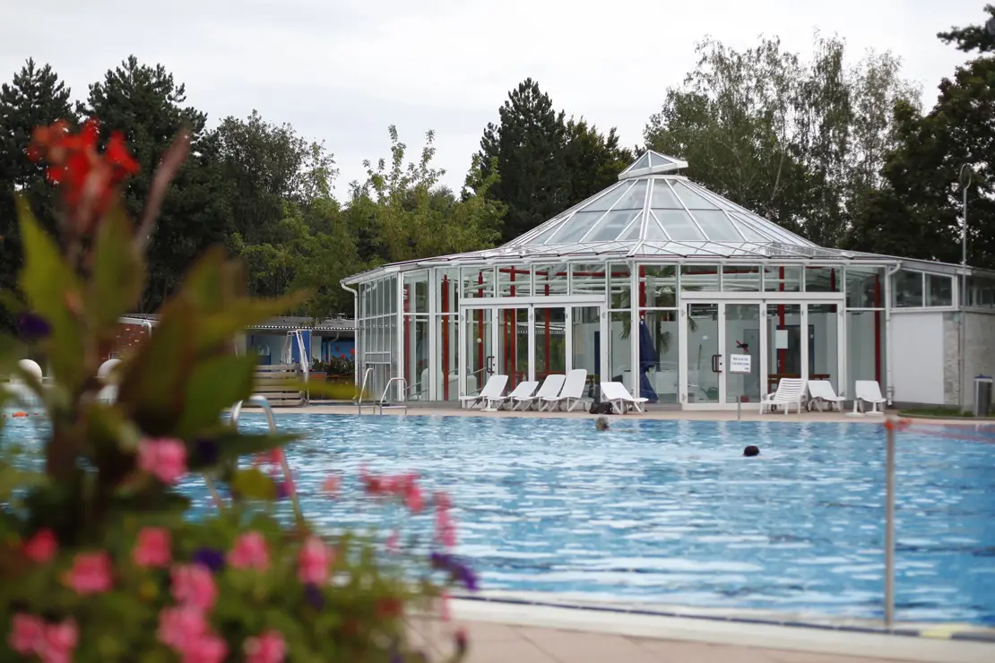 Wärmehalle Freibad Möhringen Außenansicht Wärmehalle und Liegestühle im Hintergrund des Mehrzweckbeckens im Freibad Möhringen.